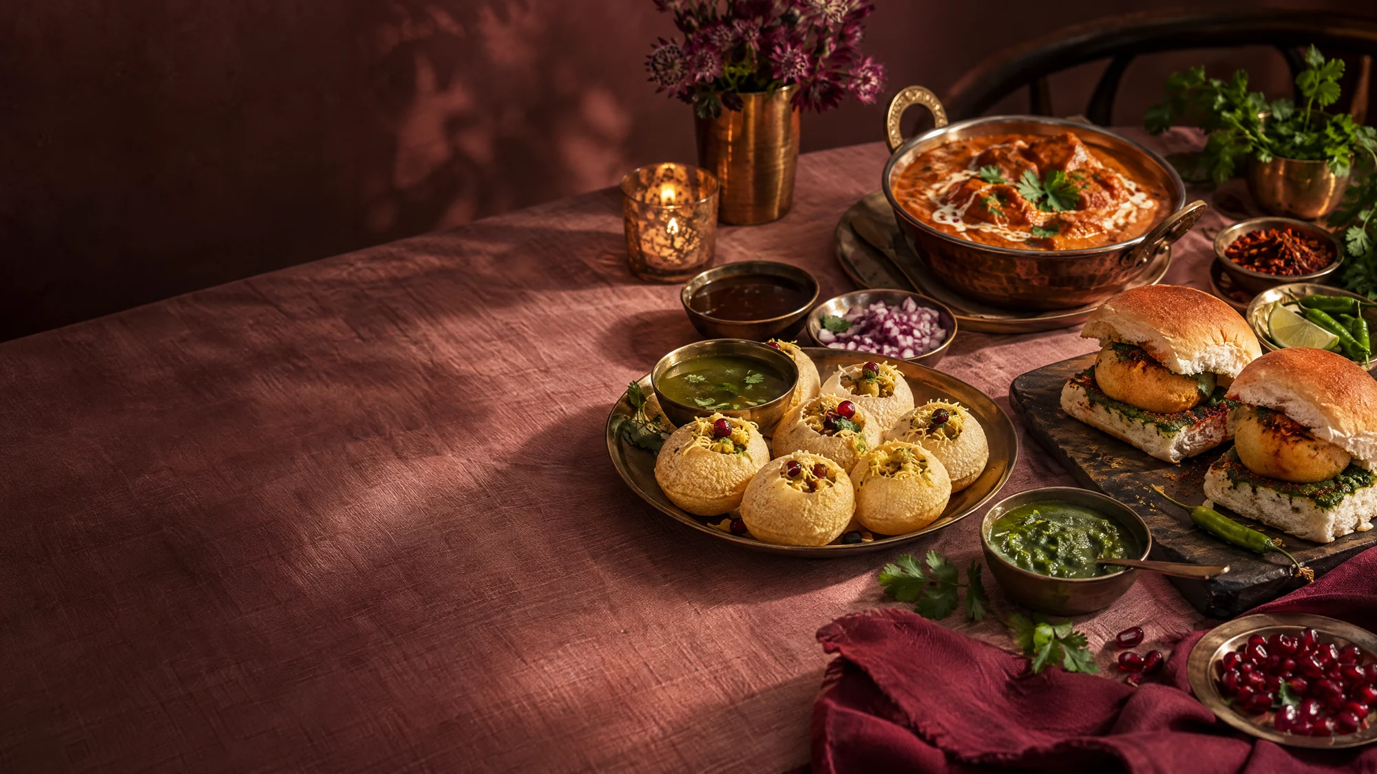 Illustrative spread of Mumbai street-food favourites on a pink table